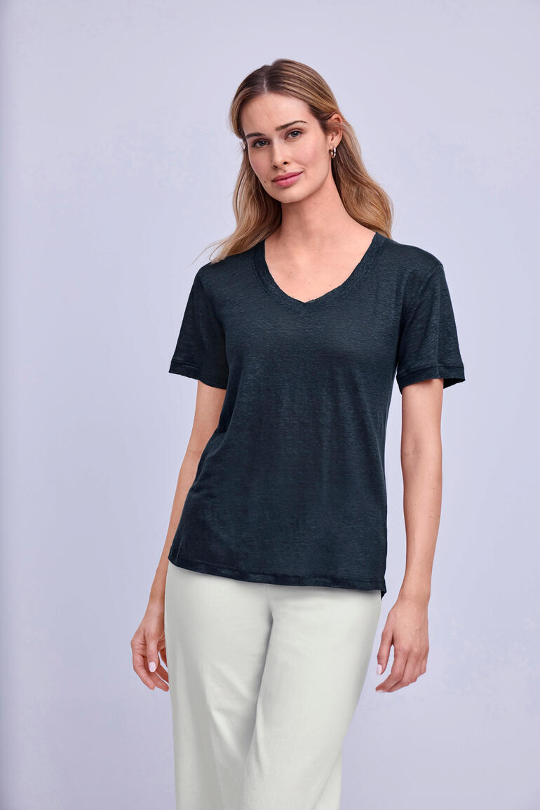 Bleu jean Femme portant un t-shirt en lin noir avec un col en V.