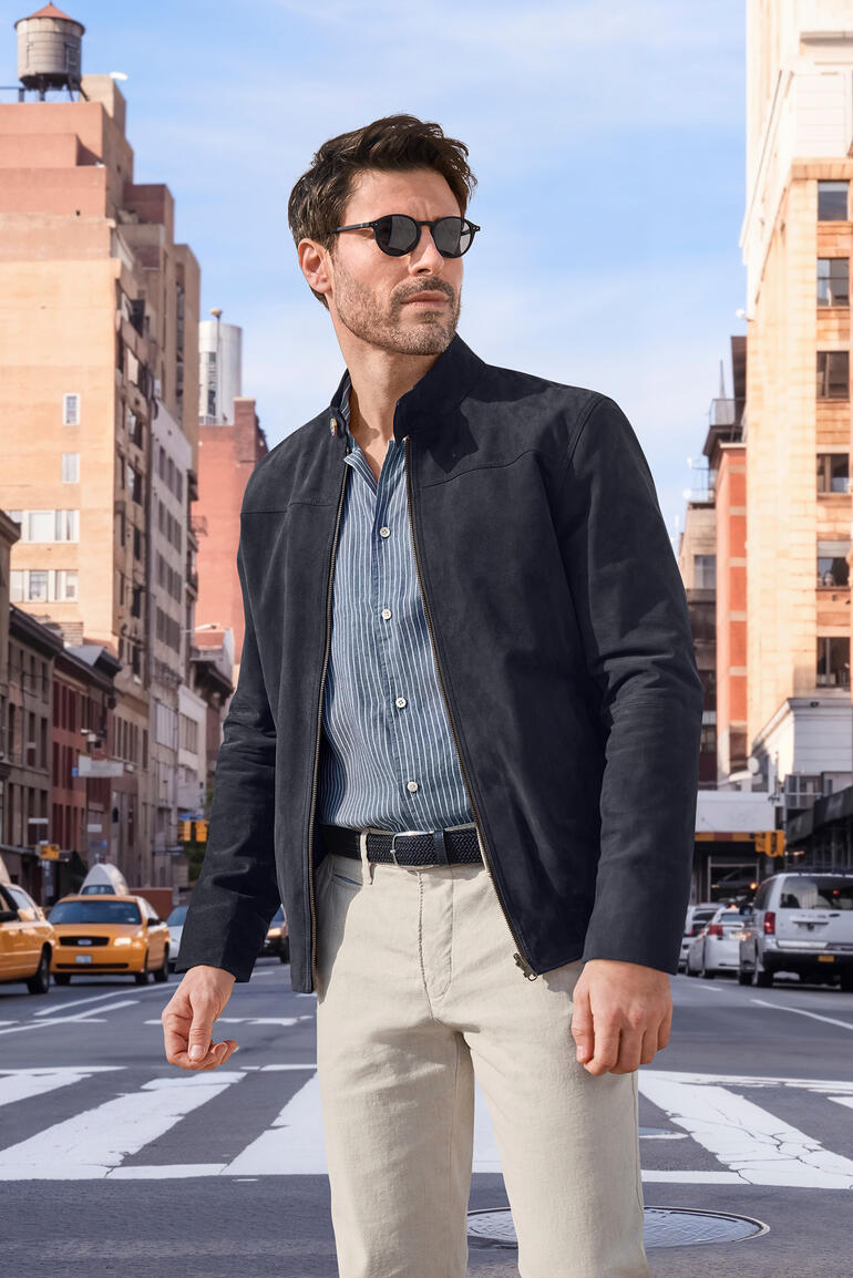 Homme portant une veste en cuir réversible OCONI sur une rue de la ville avec des lunettes de soleil