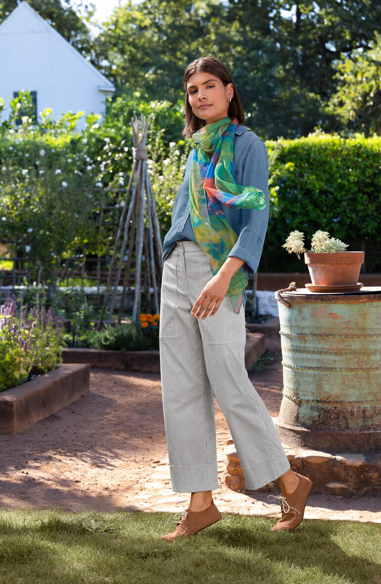 Chemise en jean Bella Dahl bleue, portée par une femme dans un jardin.