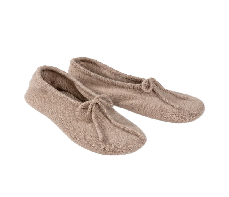Deux chaussons de voyage en cachemire beige clair côte à côte.