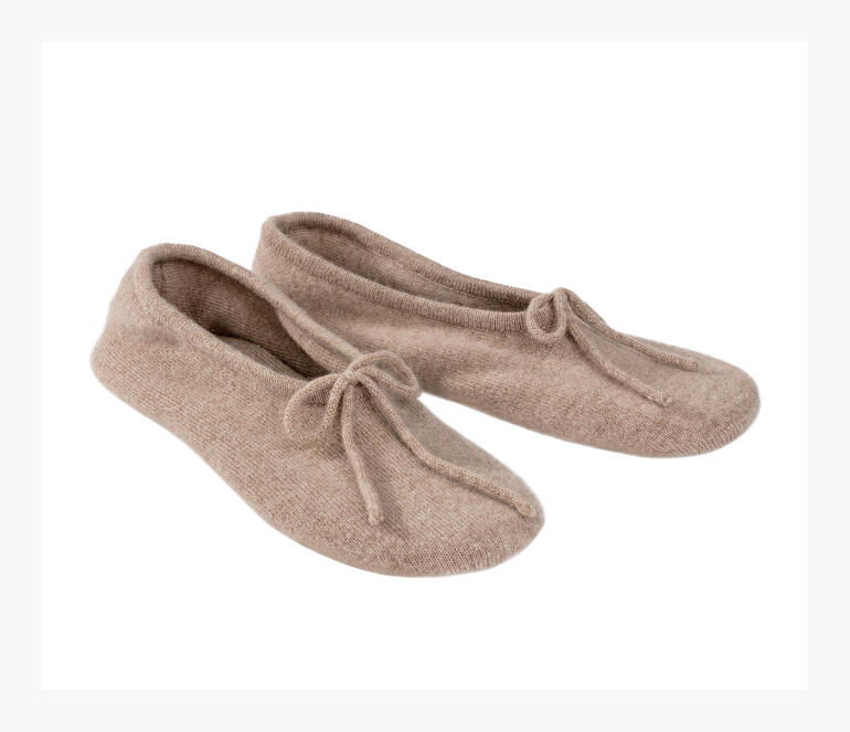 Deux chaussons de voyage en cachemire beige clair côte à côte.