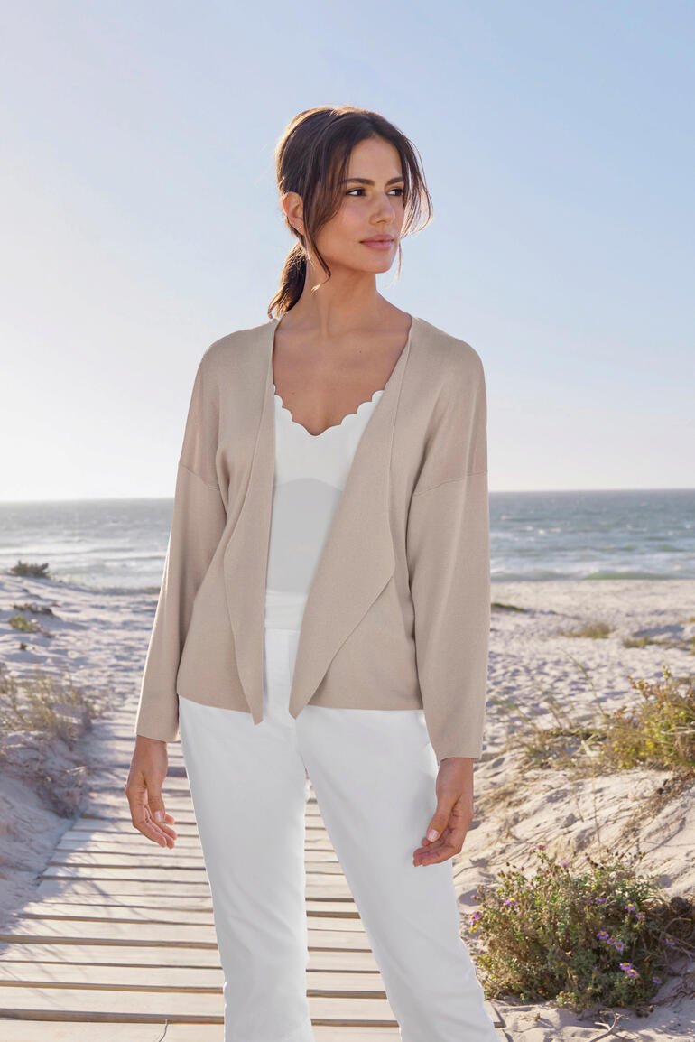 Cardigan à col cascade Femme porte un cardigan cascade à la plage, soleil brille.