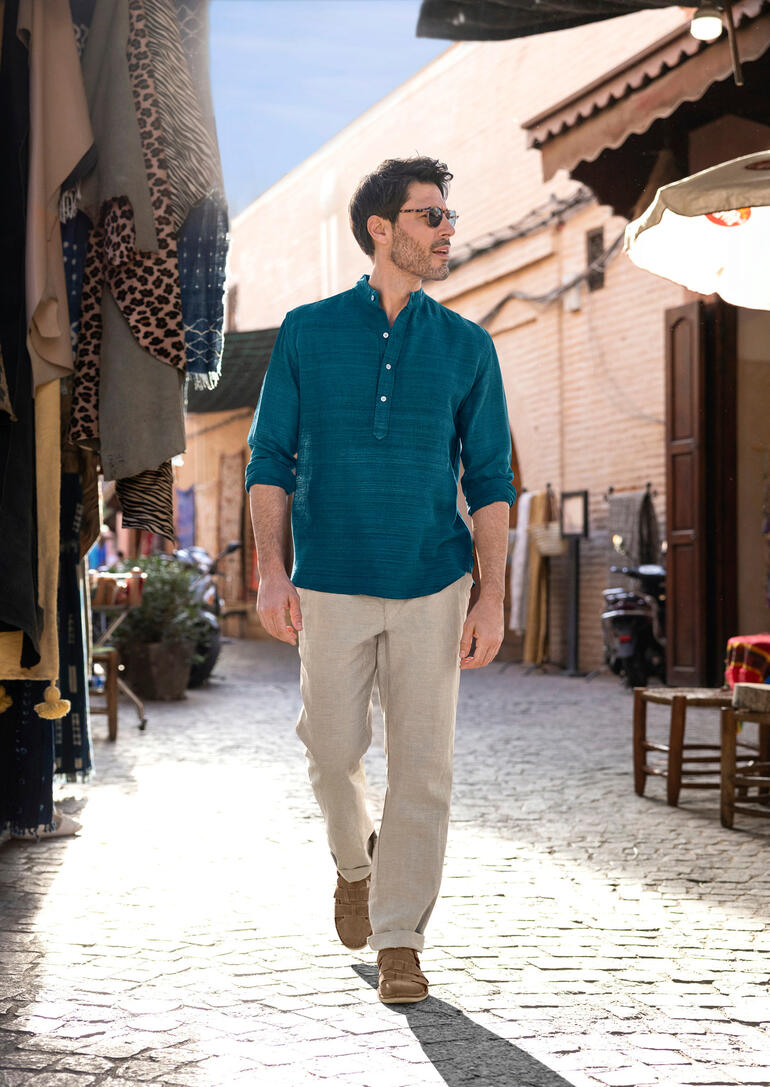 Homme portant une kurta en soie tissée à la main dans un marché animé.
