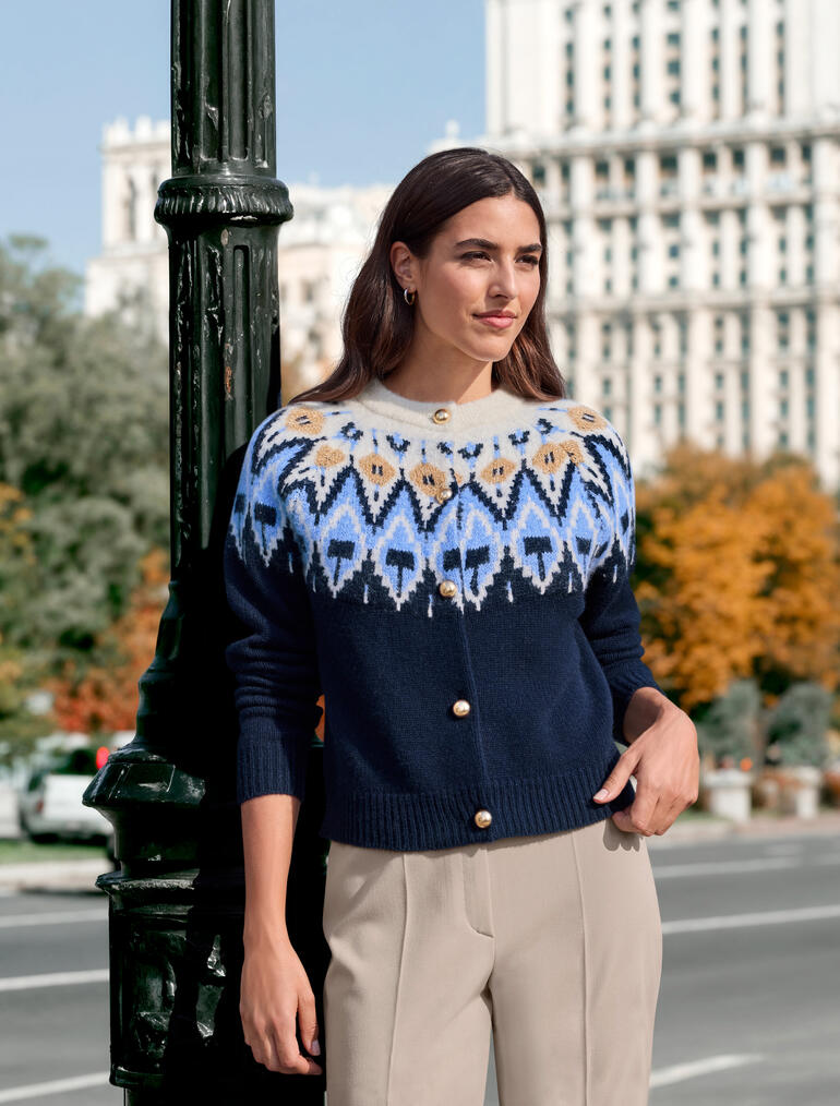 Femme portant un cardigan norvégien couture JH1954 avec motifs colorés