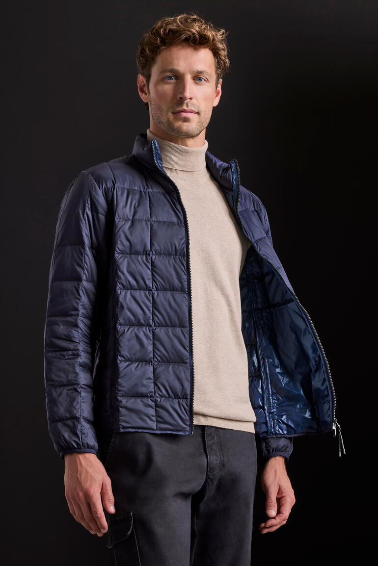Veste en duvet Taion Homme portant une veste en duvet Taion navy dans un studio.