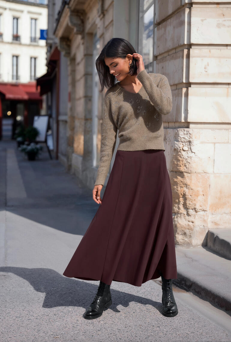 Pull en polaire Raccoon en brun, porté par une femme dans une ambiance urbaine.
