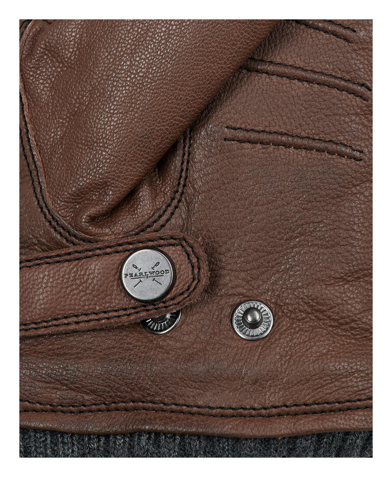 Brun Détail d'un gant marron avec un bouton pression.