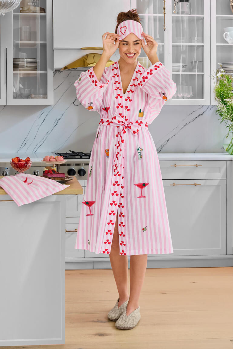 Femme portant un pyjama rayé avec bonnet dans une cuisine moderne.