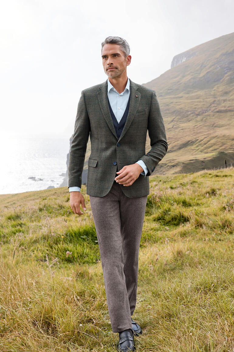 Veston et Gilet Homme en veste Donegal dans un champ au bord de la mer