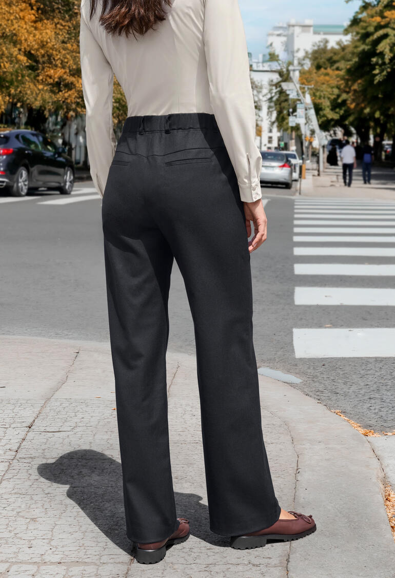 Femme de dos en pantalon en lyocell et laine marine dans la rue.