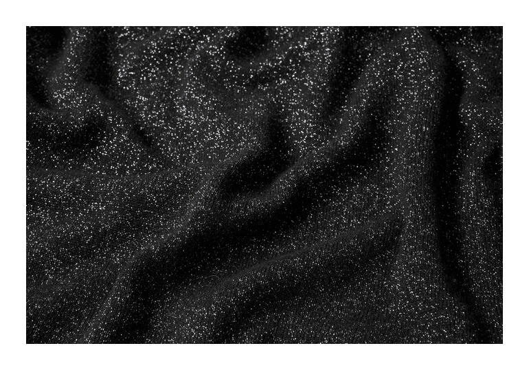 Gros plan du tissu du pull glamour en noir.