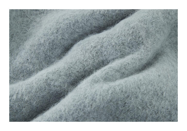 Gros plan de la texture de l'écharpe en alpaga brossé gris.
