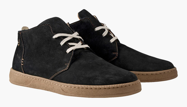 Chaussures chukka ultralégères noires avec lacets clairs sur fond neutre.