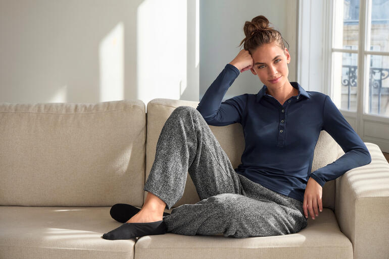 Femme portant un pull maritim en alpaga JH1954 offwhite sur un canapé.