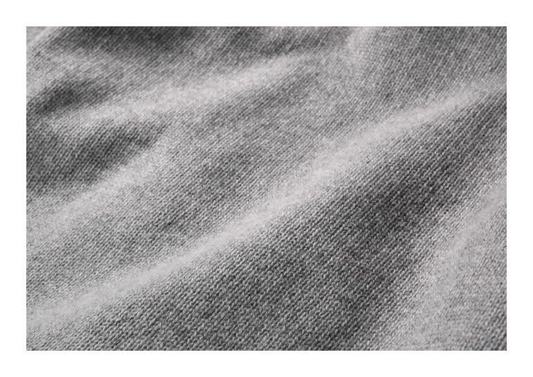 Gros plan sur le tissu gris du hoodie H en cachemire bouilli.