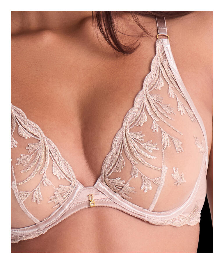 Gros plan d'un soutien-gorge avec des broderies délicates en couleur sable.