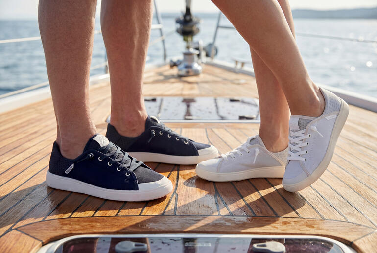Couple en sneakers debout sur le sol d'un bateau.