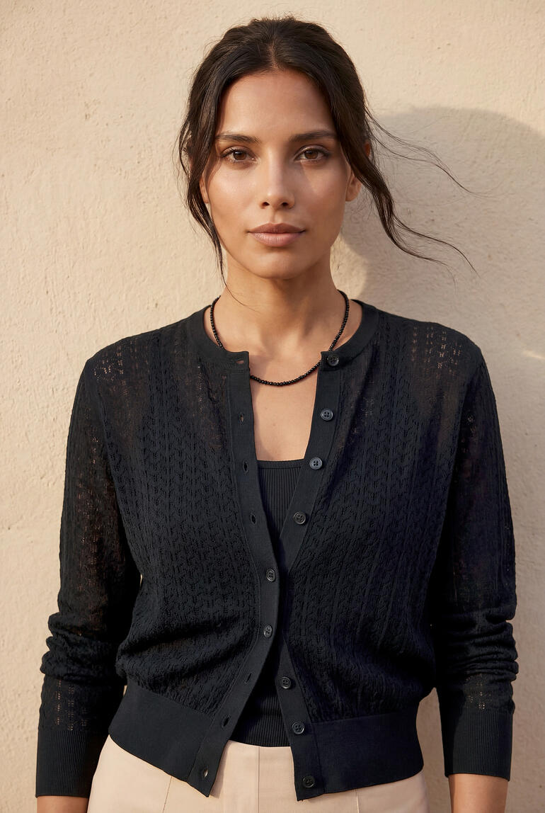 Cardigan ajour John Smedley noir porté par une femme