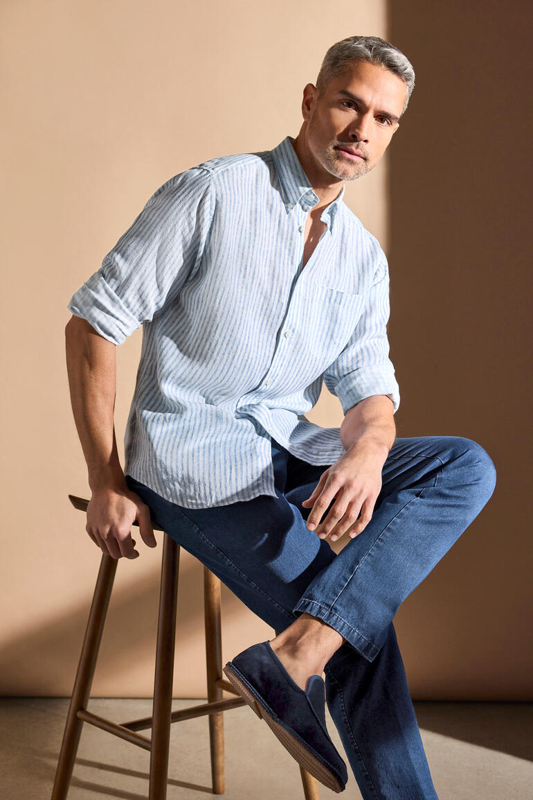Homme en chemise en lyocell-lin blanc et bleu rayé, taille 38, assis sur un tabouret.