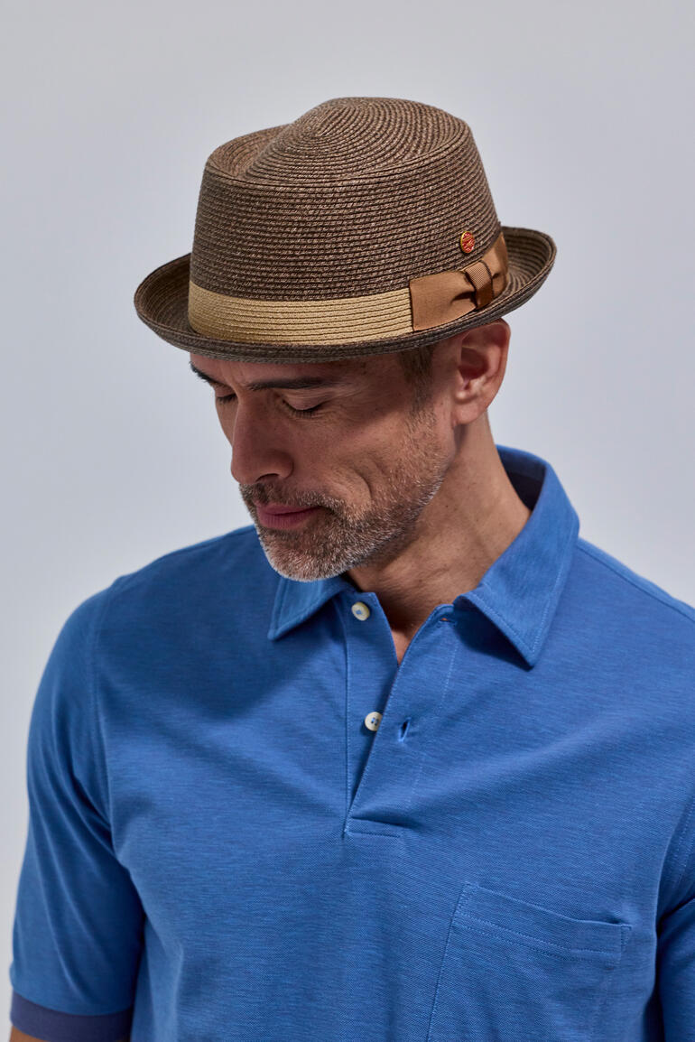 Chapeau Pork Pie brun avec accent rouge, porté par un homme aux cheveux courts.