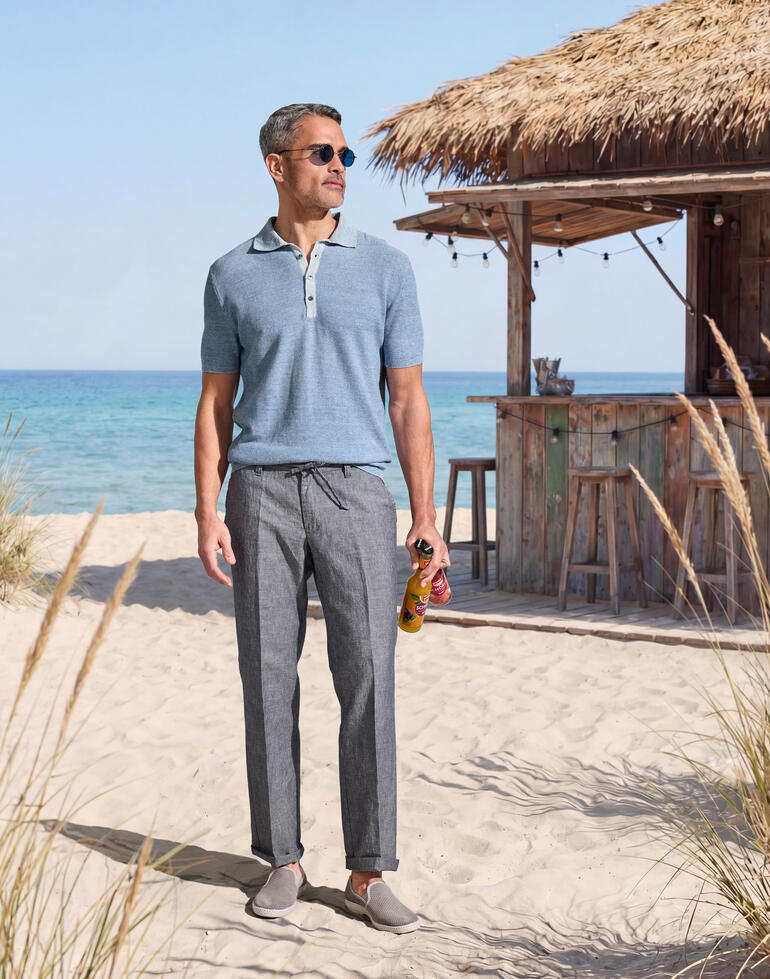 Homme en polo bleu clair se tient sur la plage