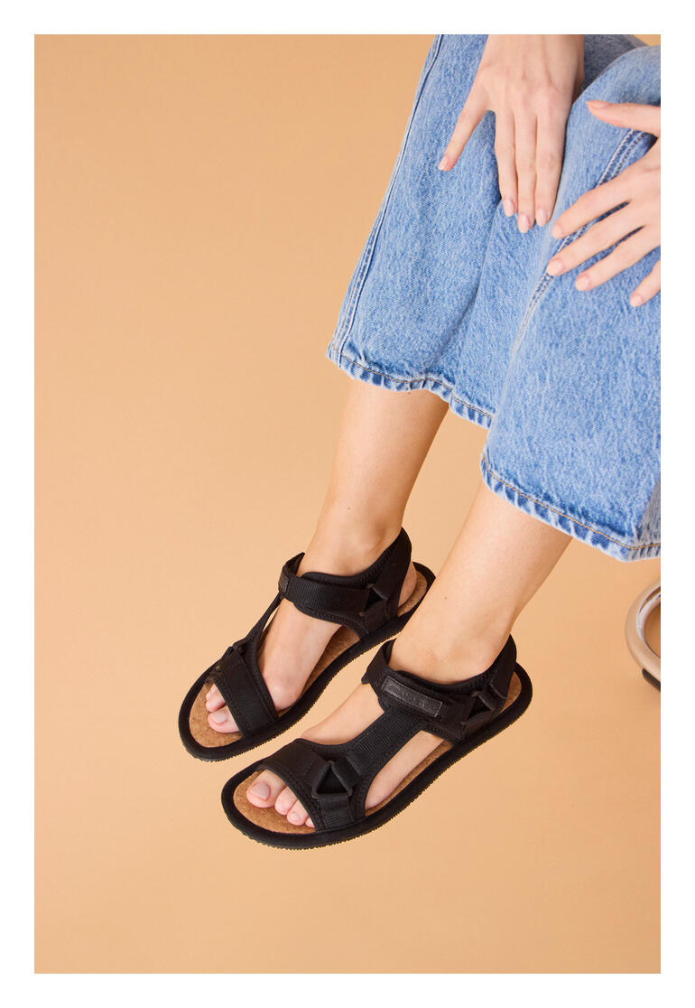 Sandale de randonnée barefoot Grand Step en noir, portée par une femme