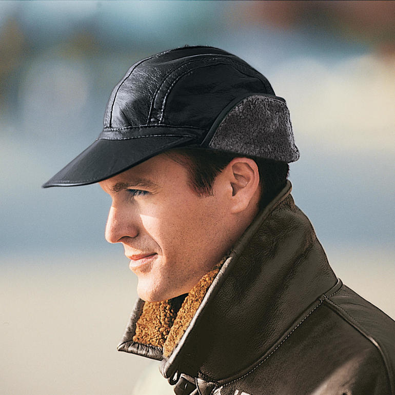 Homme portant une casquette en agneau noir dehors.