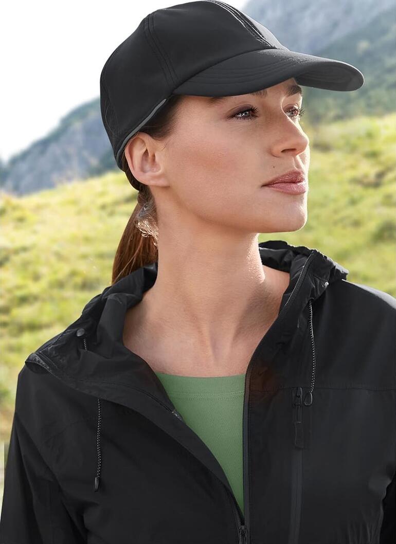 Casquette Softshell Femme avec une casquette softshell noire et une veste dans un paysage naturel.