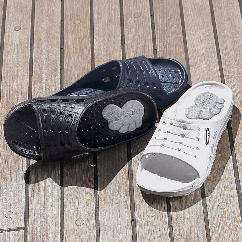 Duxilettes noires et bleues côte à côte sur fond en bois, sandales confortables et pratiques.