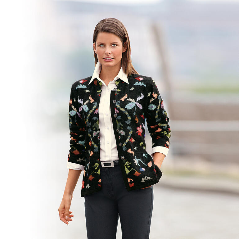 Noir/Multicolore Cardigan en alpaga Flowers, porté par une femme devant un arrière-plan flou.