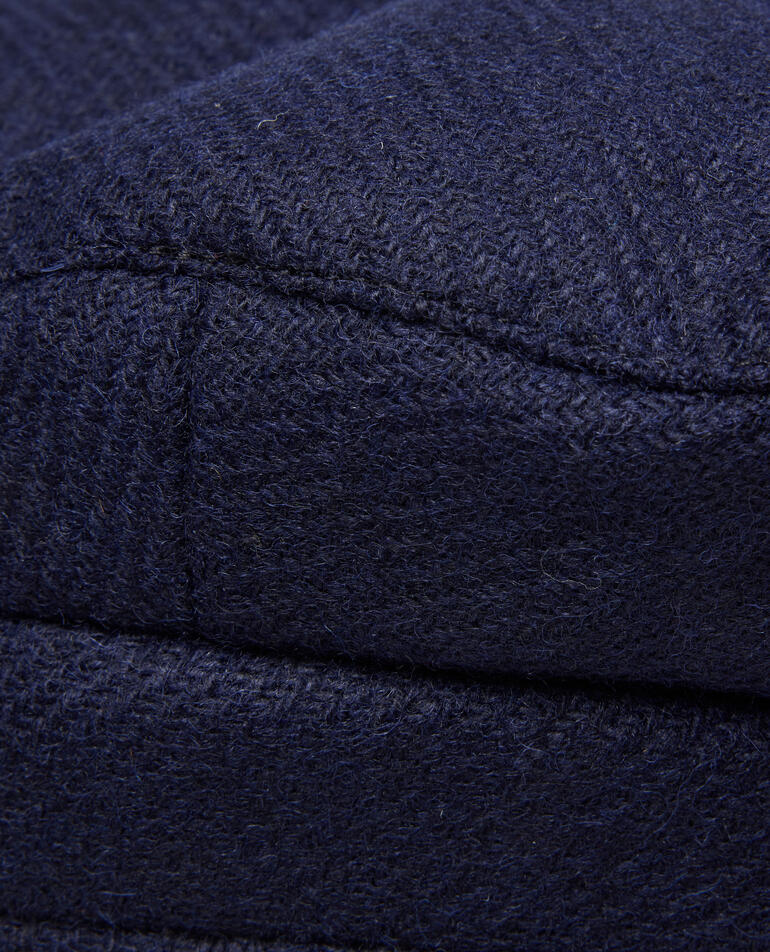 Gros plan sur un tissu en cachemire bleu marine avec une texture tissée.