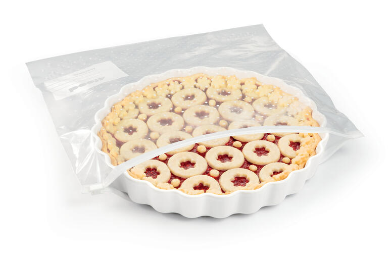 Tarte dans un emballage transparent avec garniture aux fruits.