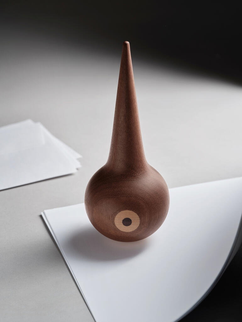 Objet décoratif en bois en forme d'oiseau avec un bec pointu.