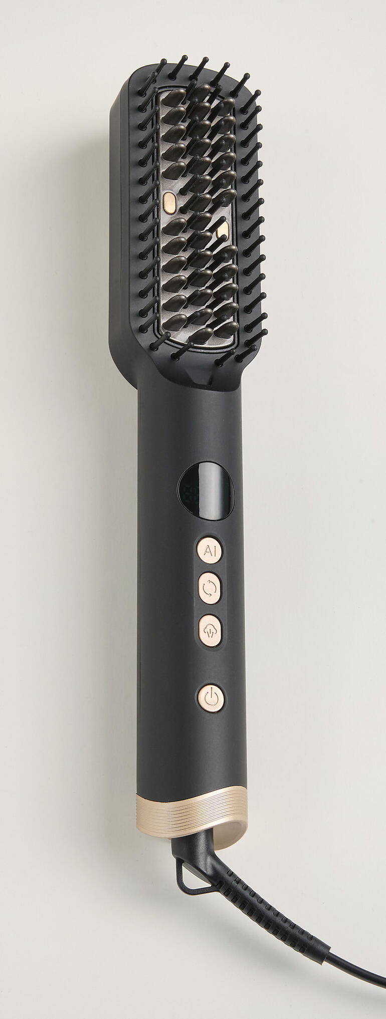 Brosse à cheveux ionique avec boutons et forme cylindrique sur fond doux.