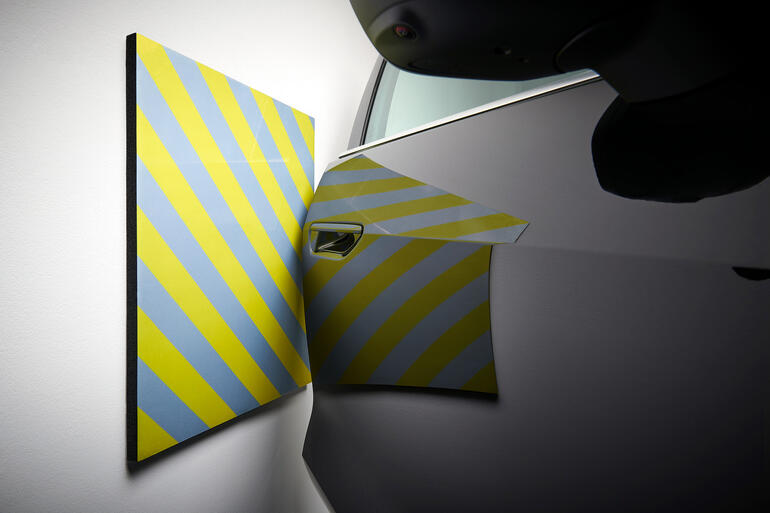 Coussin de mur de garage protégeant le mur de la voiture avec des rayures jaunes.