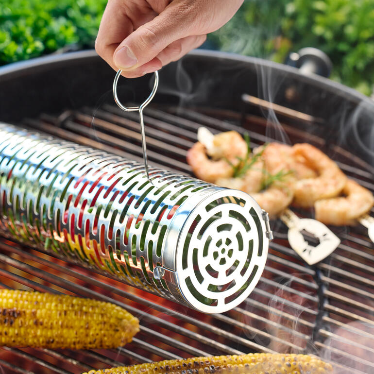 Main retirant le panier à griller du barbecue