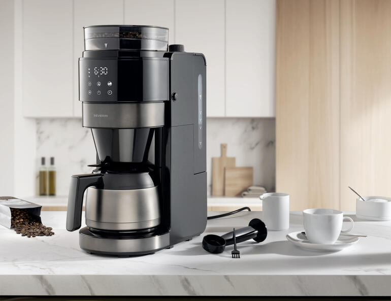 Machine à café filtre premium dans une cuisine moderne avec accessoires.