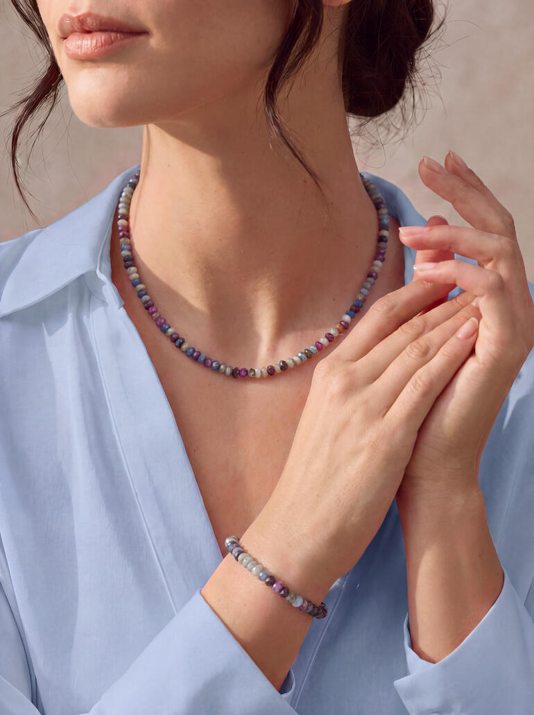 Femme portant un ensemble de bijoux Chamäleon avec un collier et un bracelet en perles colorées.