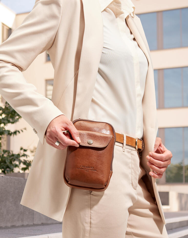 Gros plan du sac à smartphone 2-en-1 Chiarugi, assorti à une tenue élégante.