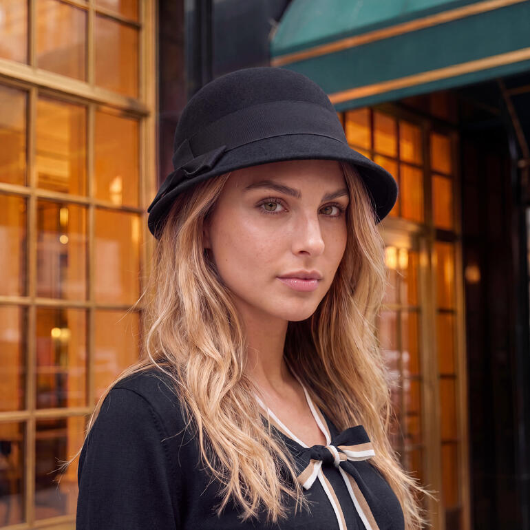 Femme dans un chapeau cloche en feutre de mérinos noir avec un large bord