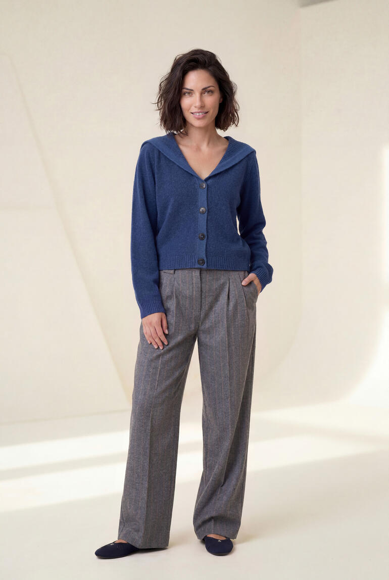 Femme souriante en pantalon à rayures larges st.Ann et cardigan