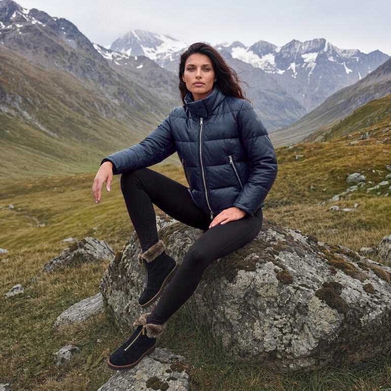 Femme en doudoune bleue foncée et leggings noirs dans un paysage montagneux