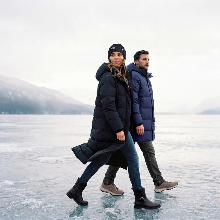 Couple portant des parkas matelassées imperméables dans un paysage de lac gelé