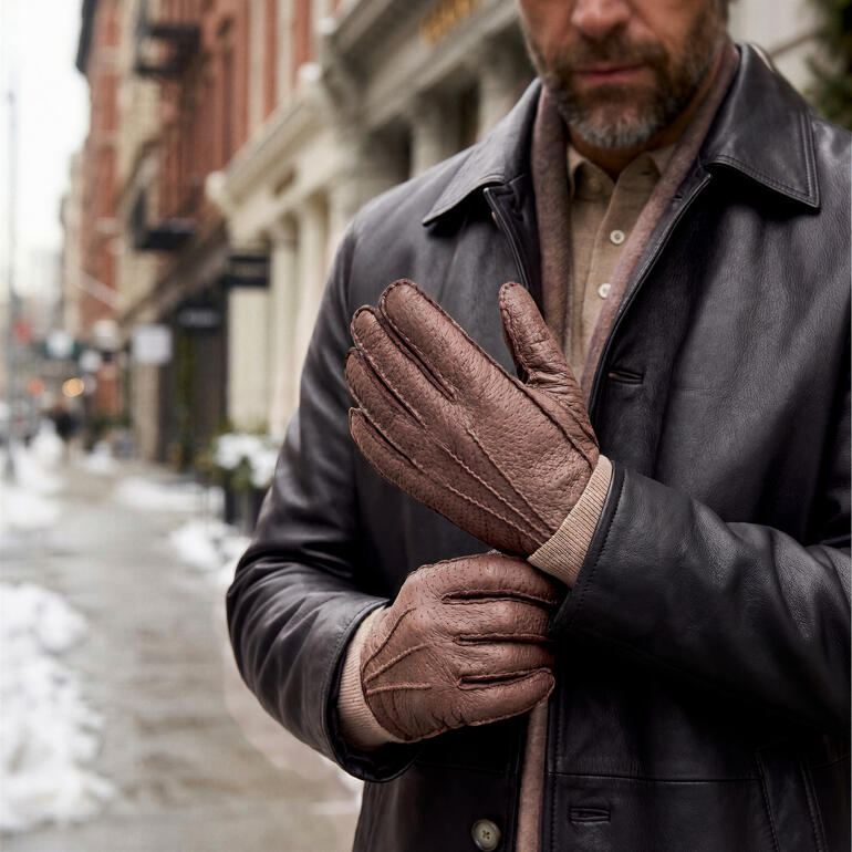 Homme portant des gants en peccary marron dans la ville.