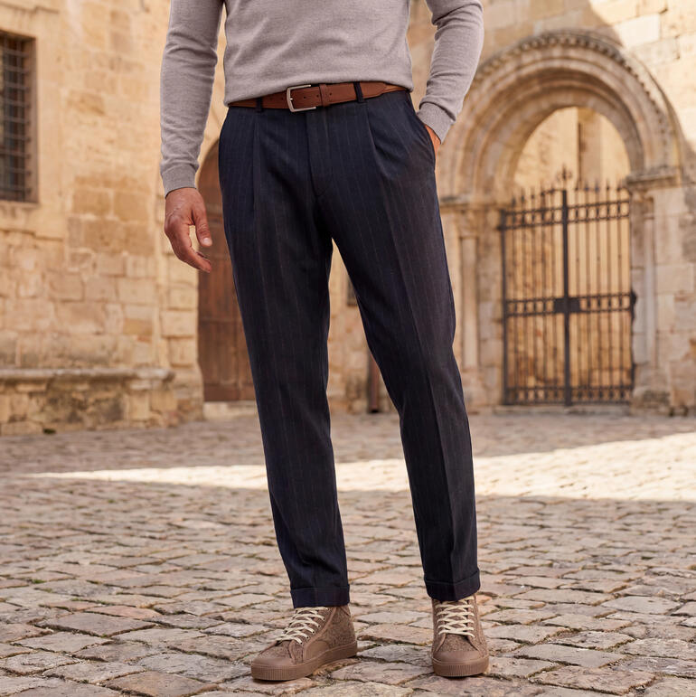 Homme portant un pantalon à rayures debout sur des pavés