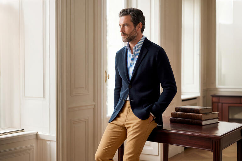 Homme en blazer Milano Knit bleu marine dans une pièce élégante