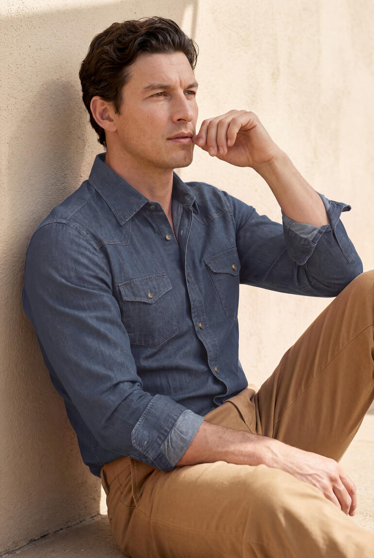 Homme assis dans une chemise western en lyocell, pensant.