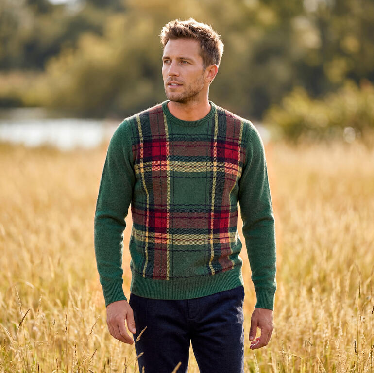 Homme en pull tartan se tenant dans le champ