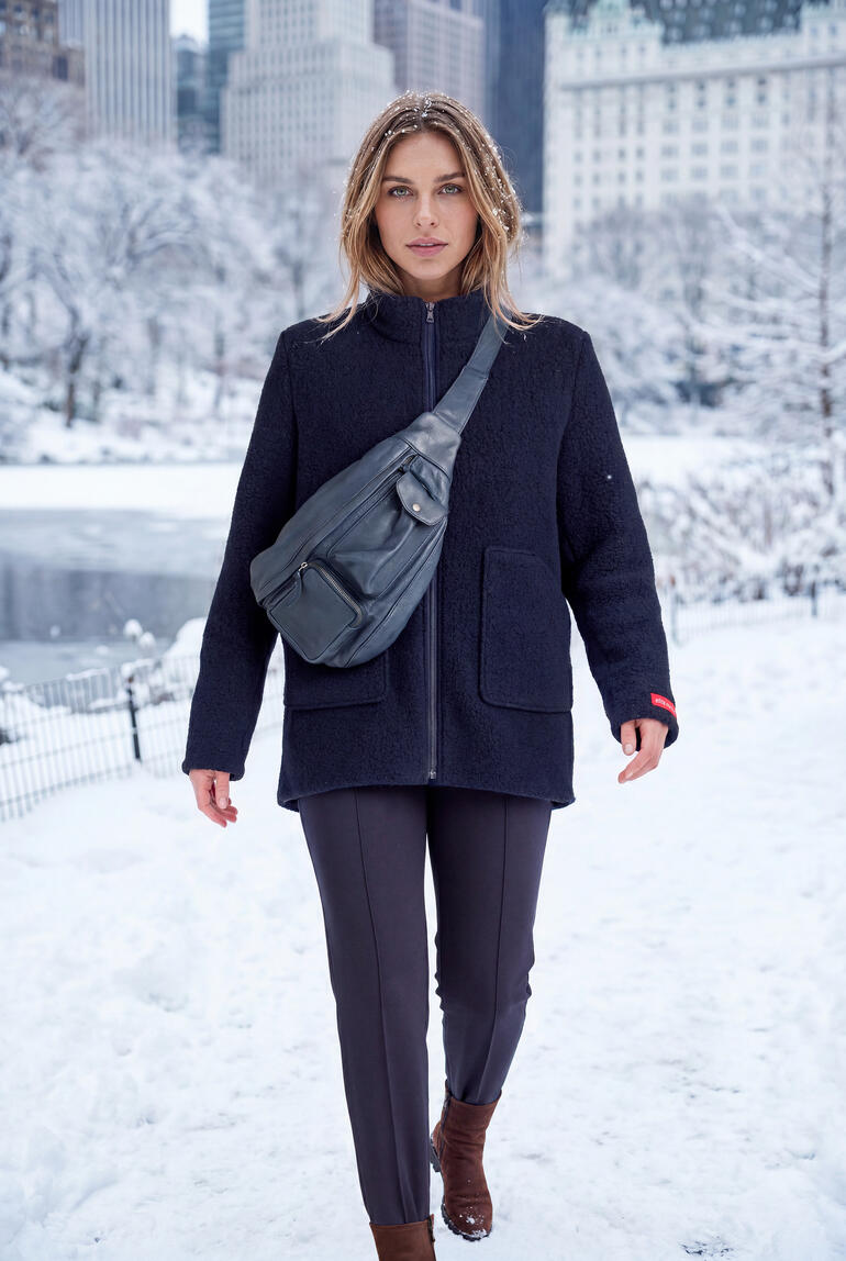 Femme portant une veste en sherpa en laine noire en hiver.
