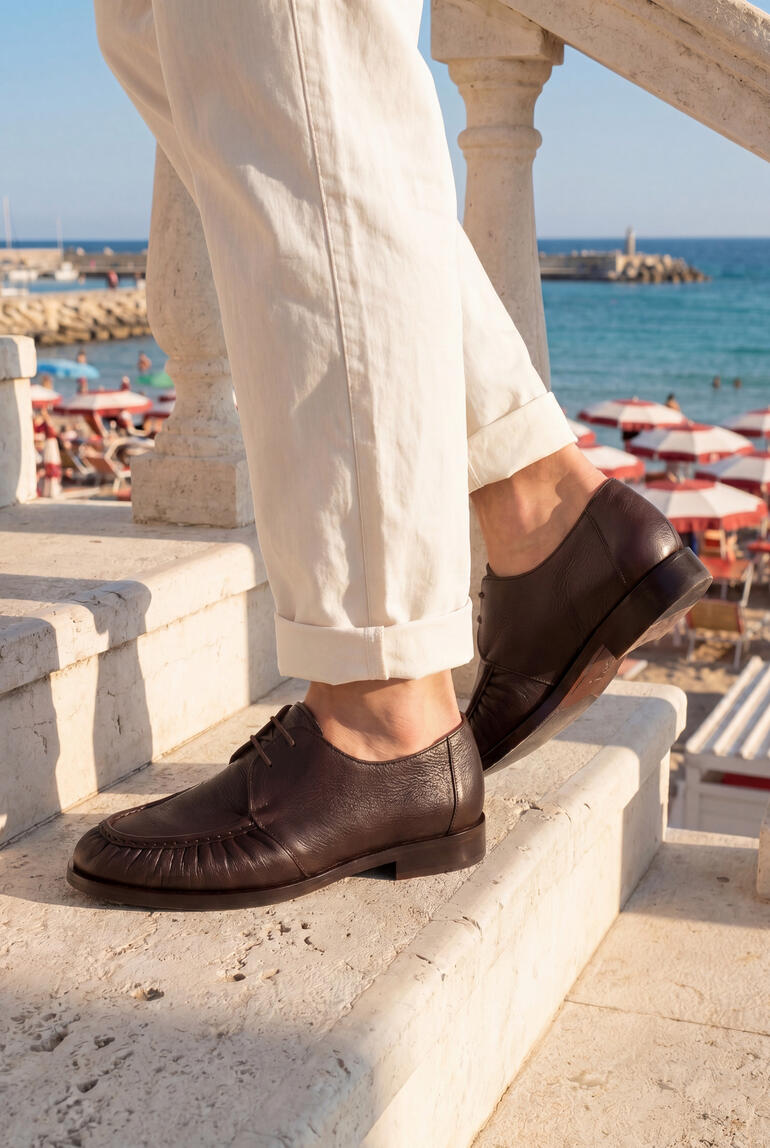 Vue complète des derby en chocolat foncé avec un pantalon blanc.